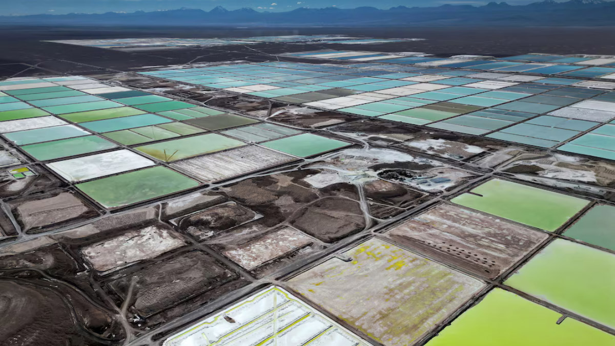 Aerial view of multicolored lithium brine evaporation ponds across Argentina’s salt flats.