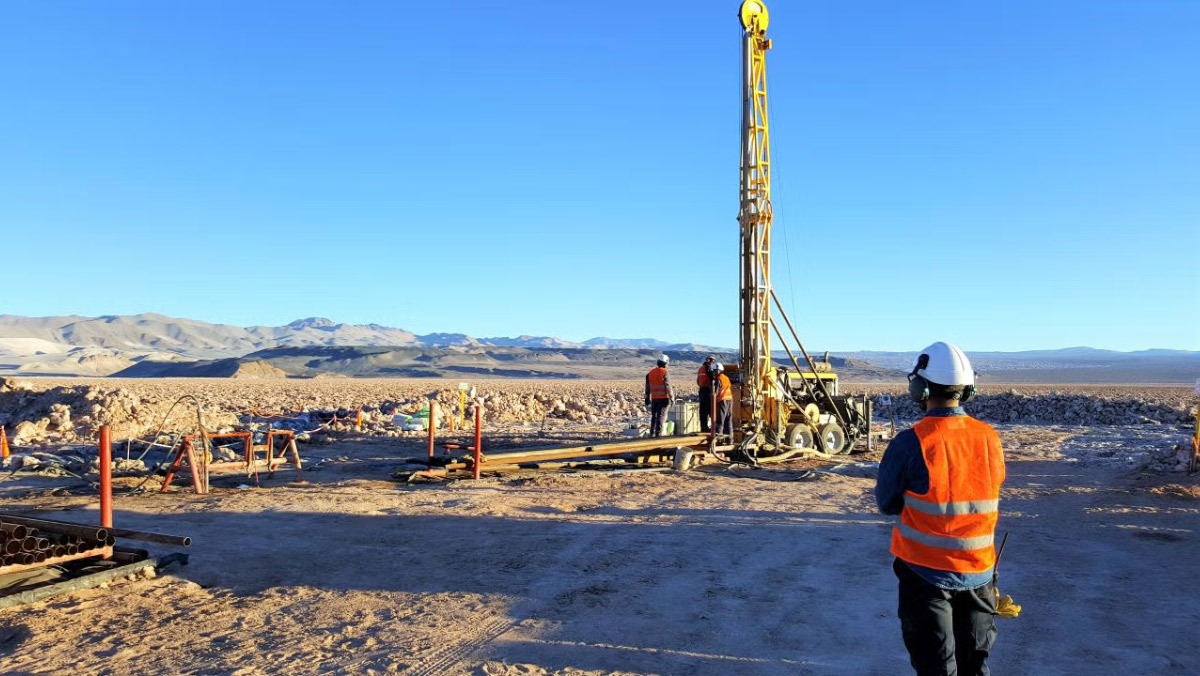 Workers operating a drilling rig on the Kachi salt flat during lithium exploration.