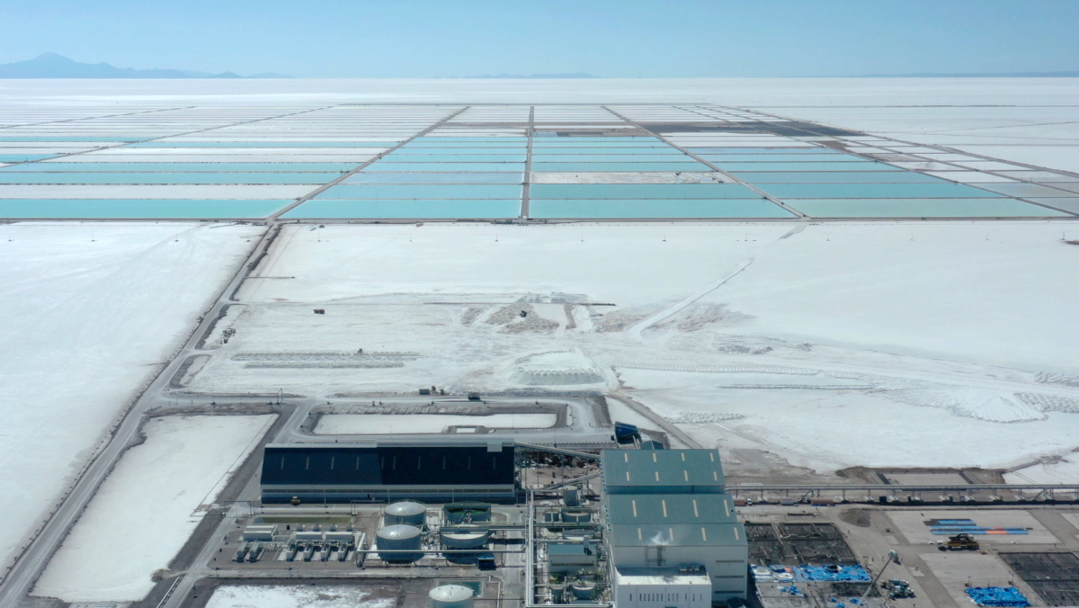 Aerial view of South American lithium evaporation ponds and processing facilities in a vast salt flat.