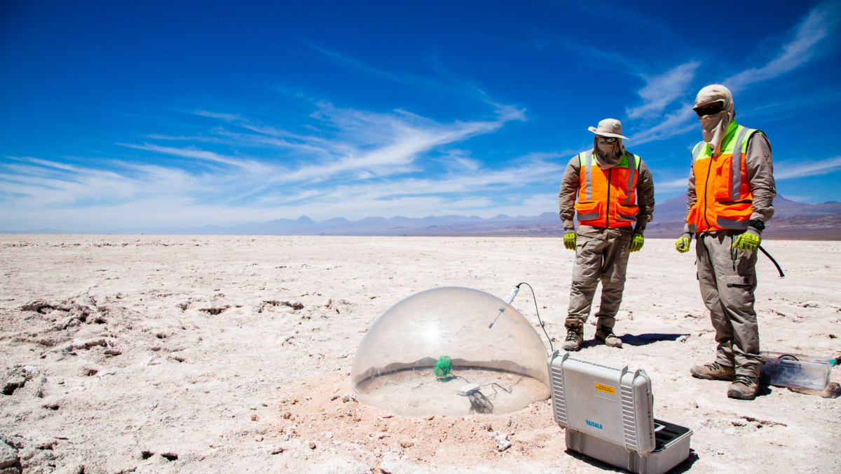 Researchers inspecting DLE field equipment on a dry salt flat in Argentina