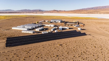 Aerial view of a lithium brine operation with solar panels and salt flats stretching to distant mountains